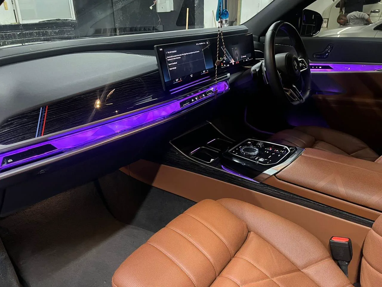 The cognac leather interior and lit dashboard of the BMW 740Li