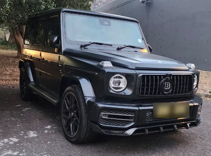 A black Mercedes G-Class with a Brabus grille badge