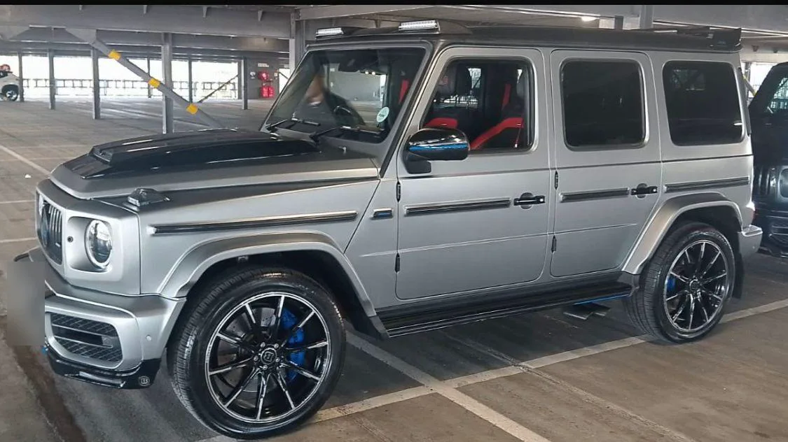 A silver Mercedes-AMG G-Class with black wheels and blue brake callipers