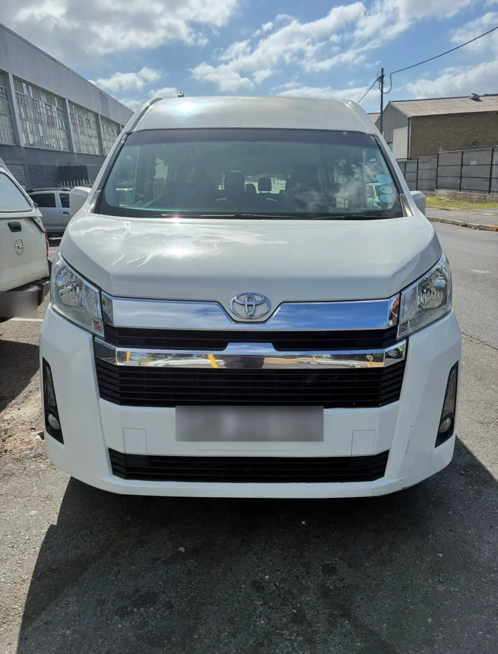 A white Toyota Quantum minibus, front view